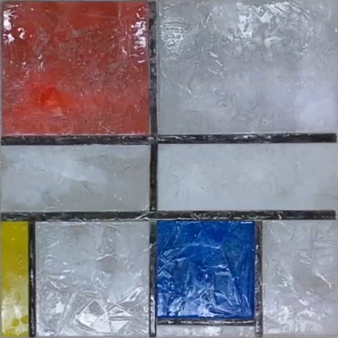 Terug naar de natuur met Piet Mondriaan nr. 1.1 — procesfoto van gekleurde ijsblokken in een Mondriaanachtig raster; rood, blauw en geel ijs beginnen te smelten op een witte ondergrond.