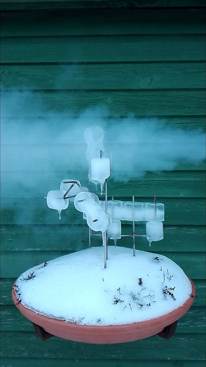 Entropic Sculpture No. 1 — videostill of the sculpture in winter where ice forms envelop the metal frame and cold vapor surrounds the work.