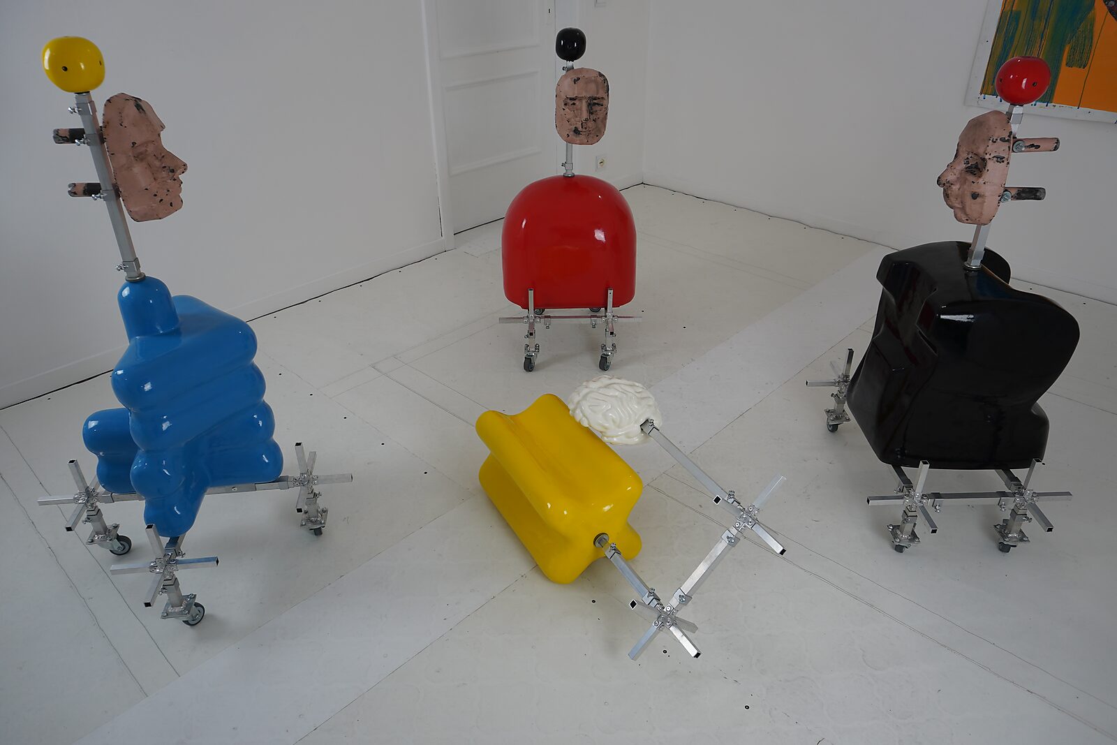 Kies en verander — atelieropstelling met meerdere sculpturen in verschillende kleuren en vormen, geplaatst op verrijdbare aluminium structuren.