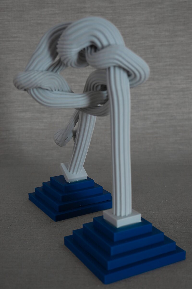 The Columns of Ovidius — Cadmus — rear view showing a twisting form winding between two columns, supported by blue bases.