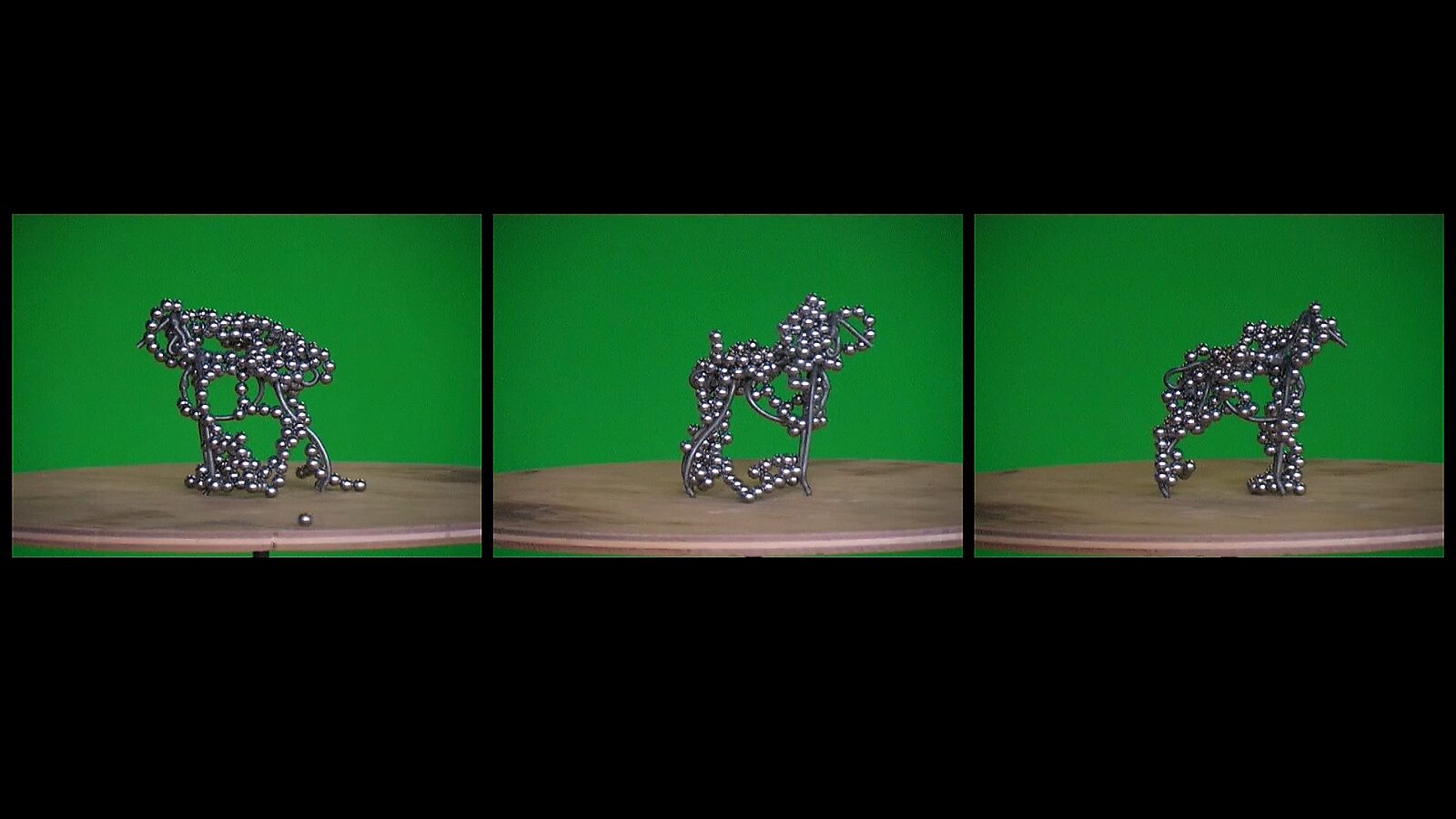 De draaihond, De veelvormige hond — videostills: compacte hondvorm volledig omhuld door metalen bolletjes, met variërende poses op de tafel.