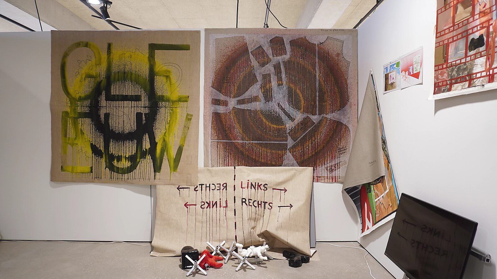 Transformatiestudio nr.1: warm of koud: Tentoonstellingszicht met een chaotische opstelling van doeken en objecten in geel-, zwart- en bruintinten, CC De Adelberg, Lommel, 2024.