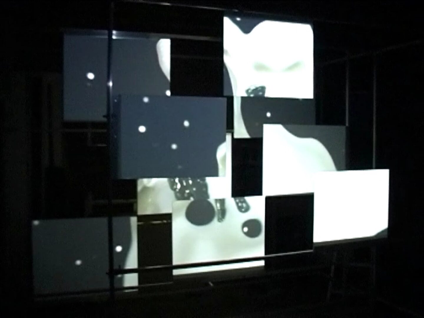 Choose and Change, Liquid Forms Through Space — photo of the installation: video image of abstract black-and-white forms fragmented across a modular screen system.