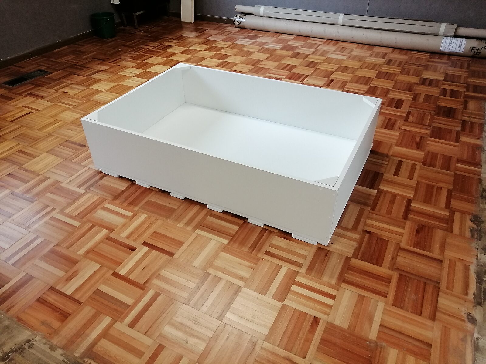 Opstelling voor Terug naar de natuur met Piet Mondriaan nr. 3 — witte bakconstructie waarin onder stenen platen een doek ligt, met afgeronde randen om het smeltende ijs binnen het kader te houden.
