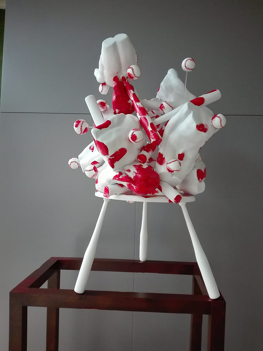 Butt’s, Bats and Balls — frontal view of the sculpture in which red traces spread across the white surface like a record of movement, as if a frozen action continues to resonate within the object.