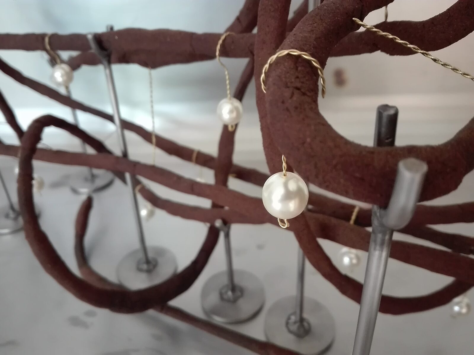 Shipbuilding — small pearls attached to the sculpture with thin wire as hanging elements.
