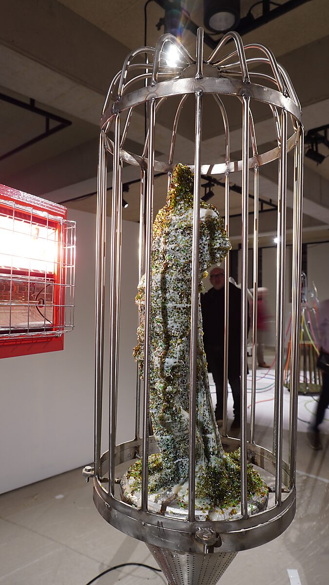 The Great Escape of Saint Sebastian — the sculpture stands again inside the metal cage during the exhibition Transformation Studio No.1: Warm or Cold at CC De Adelberg in Lommel.