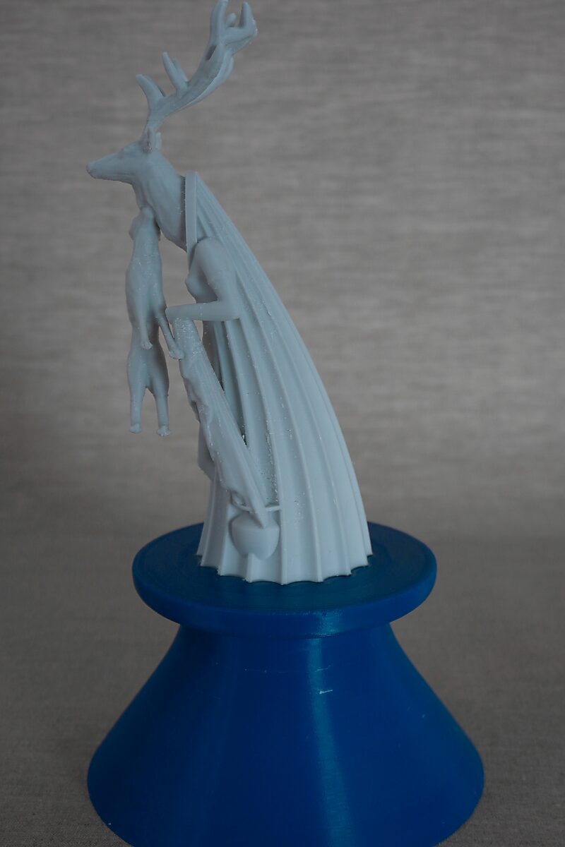 De zuilen van Ovidius — Acteon — achteraanzicht van de 3D-geprinte sculptuur met hertengewei en geplooide mantelvorm op een blauwe sokkel.