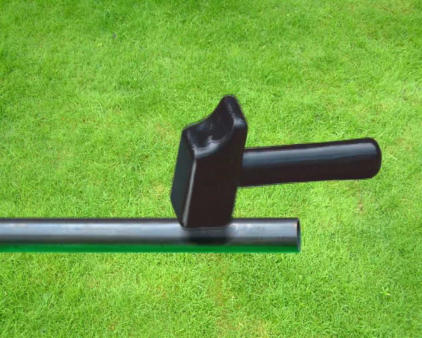 Choose and Change, The Distance to Morsmaille and Back — video stills: black hammer resting on a metal pipe against a grass background.
