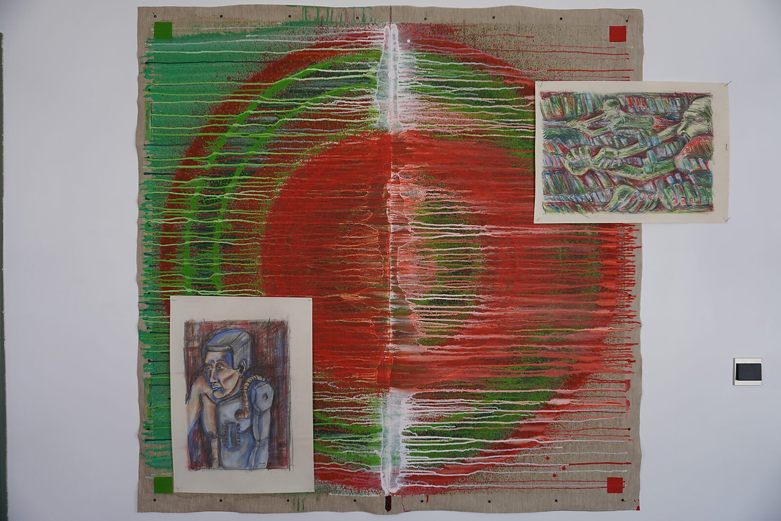 De Verdeler — The Divider — procesfoto: testplaatsing van tekeningen op het doek met rode en groene cirkelvorm.