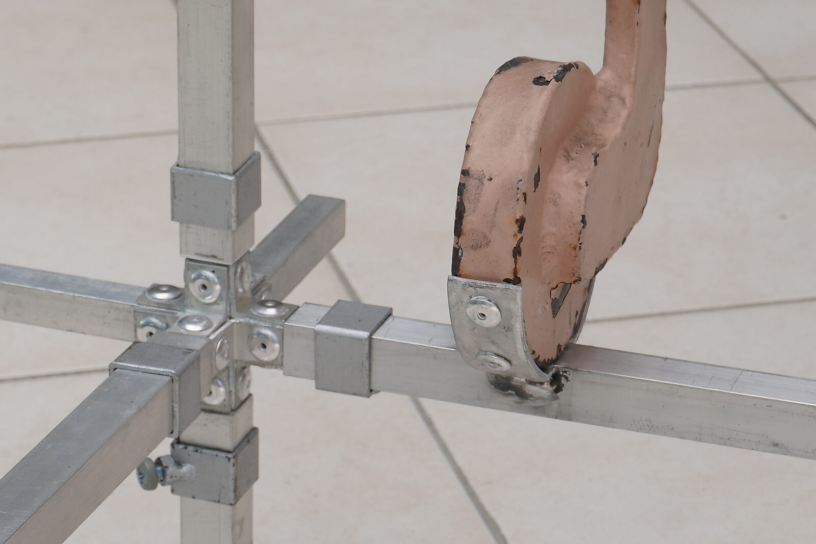 Choose and Change — aluminium construction system: detail of a metal corner joint with bolts, connected to a worn pink painted element.