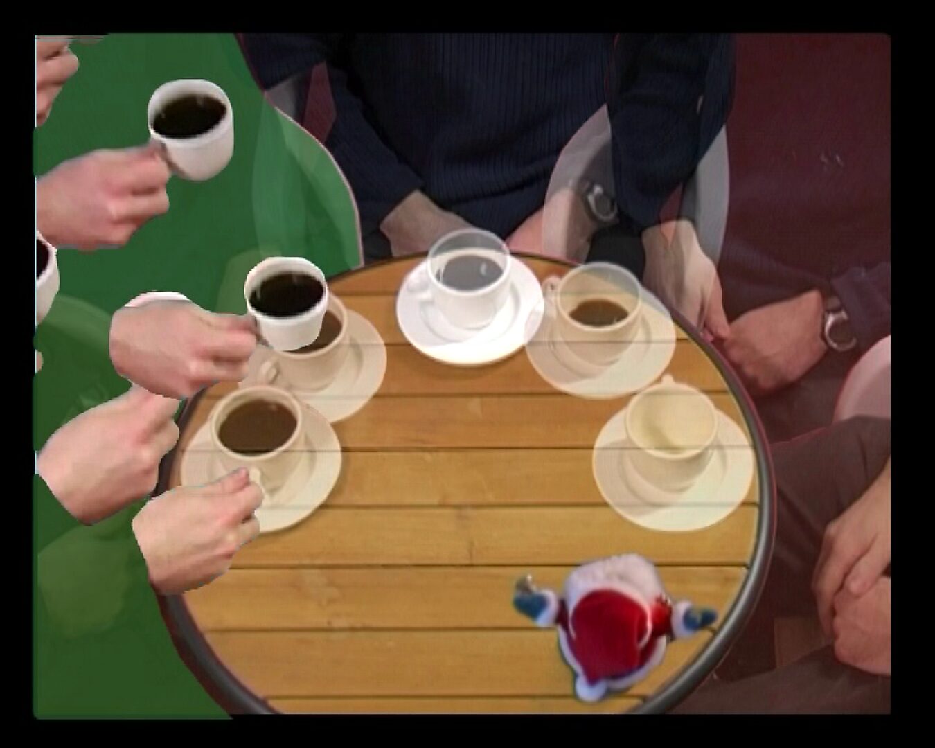 Movement and Stillness — Drinking a Cup of Coffee in 180° — video still in which several hands holding coffee cups move toward the center of the table from different directions; the small Santa figure lies on the table.