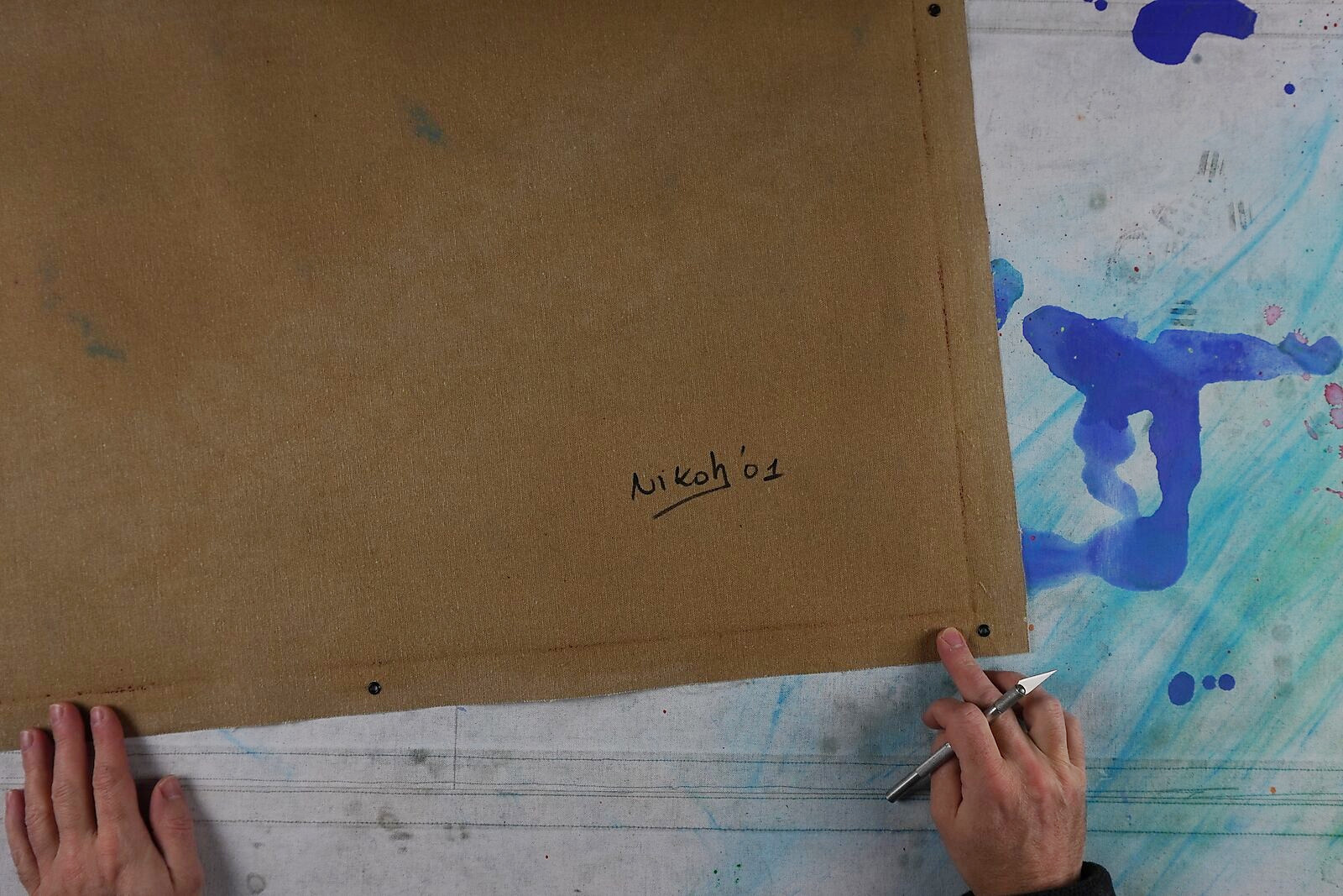 Of the Grid — view of the reverse side of the panel with signature; the object presents itself as a physical painting with a wooden support, bringing the digital grid image back to a material artwork.