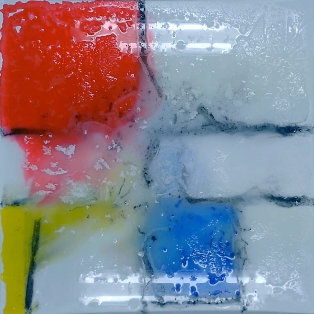 Back to Nature with Piet Mondrian No. 1.2 — process photo with visible meltwater; red and yellow pigments begin to flow along the black grid lines.