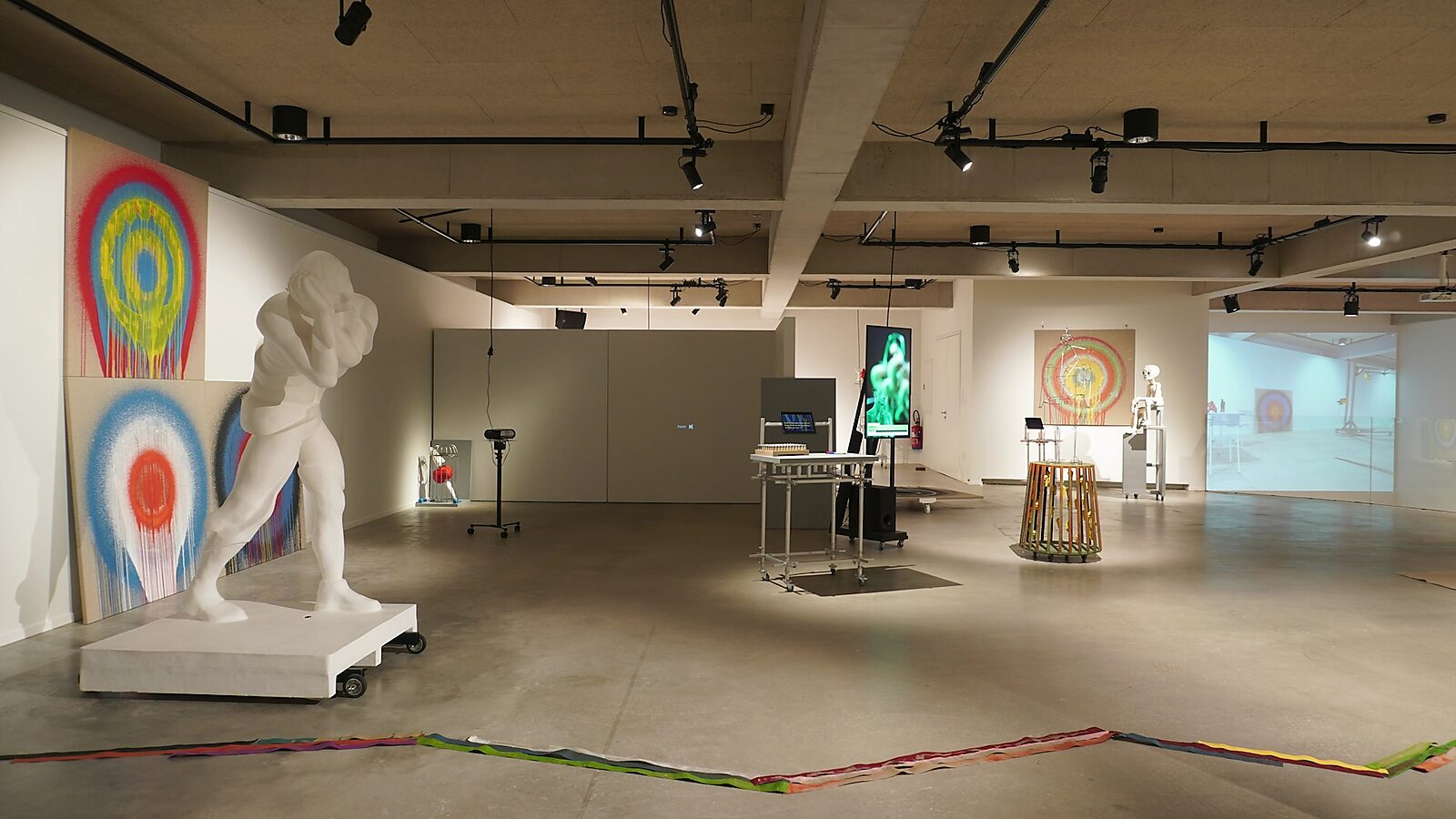 ‘Transformatiestudio nr.1: warm of koud’: Exhibition view with sculptures and paintings; video projection in the background, CC De Adelberg, Lommel, 2024.