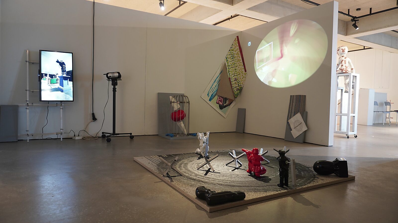 ‘Transformatiestudio nr.1: warm of koud’: Tentoonstellingszicht van een installatiehoek met kleine objecten en schilderijen, met cirkelvormige projectie, CC De Adelberg, Lommel, 2024.