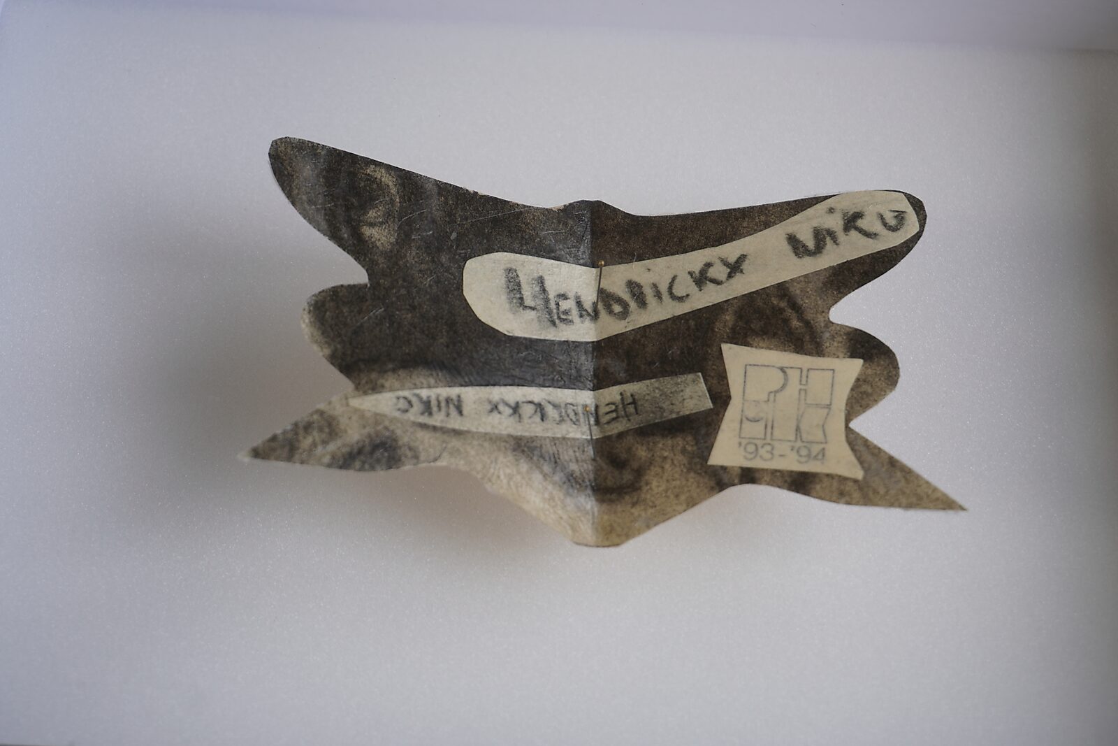 Naming–Value Butterflies — process drawing: self-portrait study 3 PHIKO (1993) — folded butterfly-shaped fragment showing parts of a face with a name strip “Hendrickx Niko” and a small label “PH 93–94”.