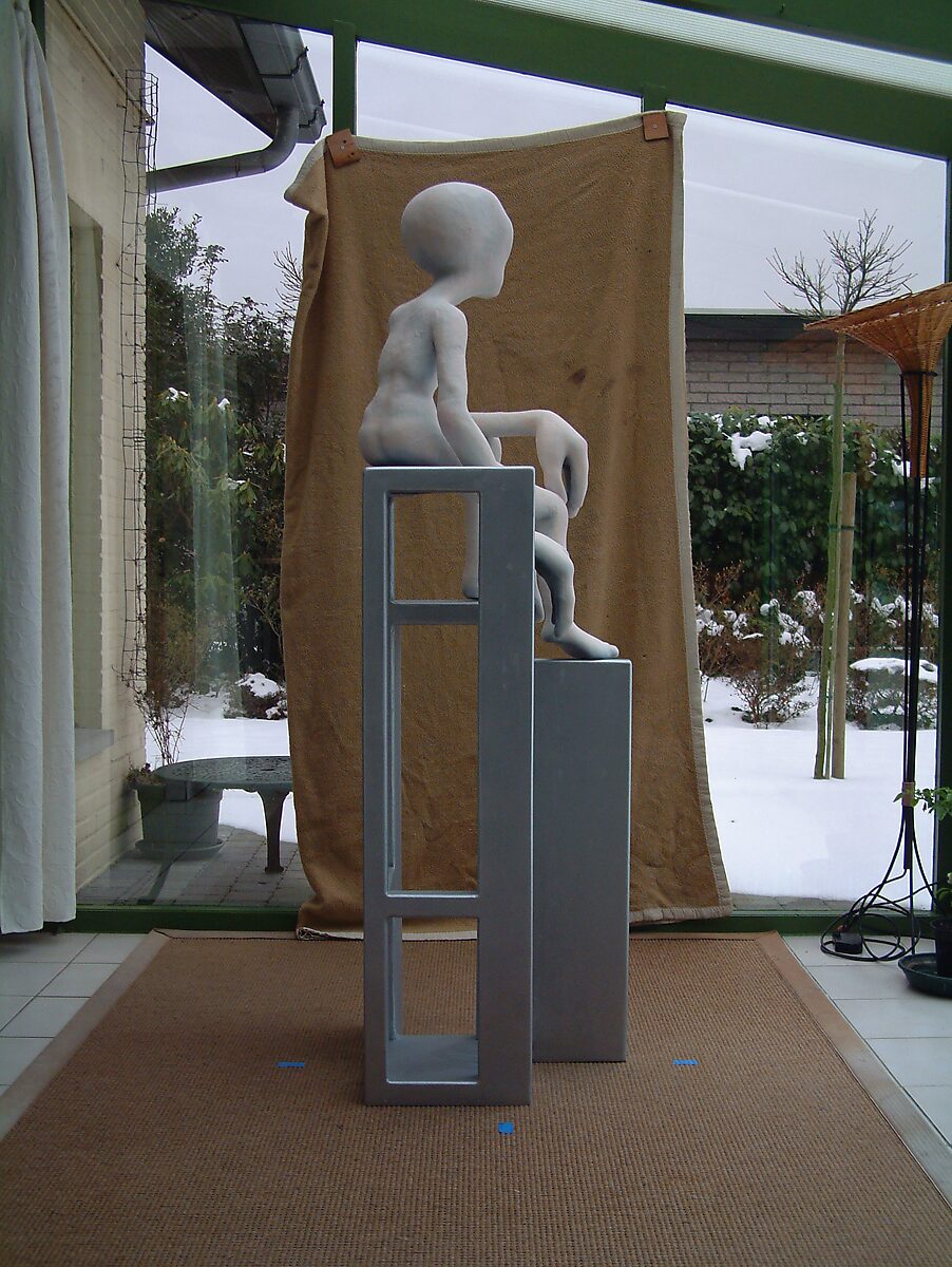 Buitenaardse zorg — achteraanzicht: bleke alienfiguur zittend op een hoekige, open stoelstructuur met rechthoekige vormen; rug licht gebogen. Bruin doek en raam met sneeuw zichtbaar op de achtergrond.