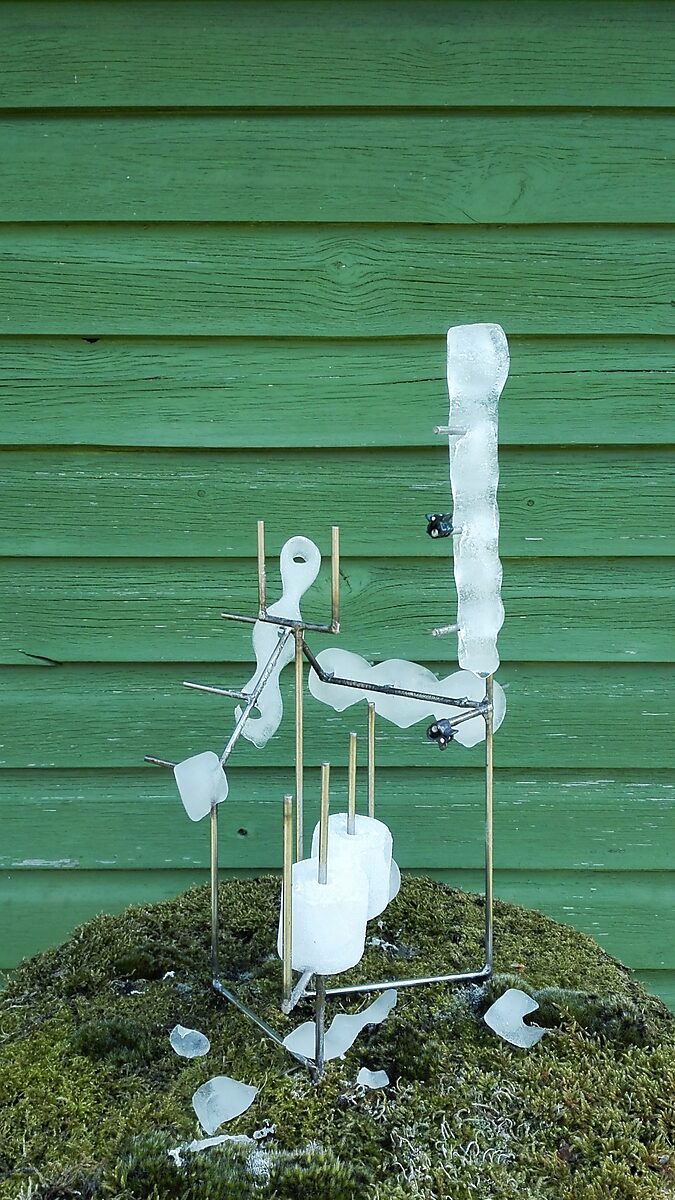 Entropische sculptuur nr. 1 — videostill waarin het ijs in de lente verder smelt en dunne transparante vormen rond het metalen frame hangen.