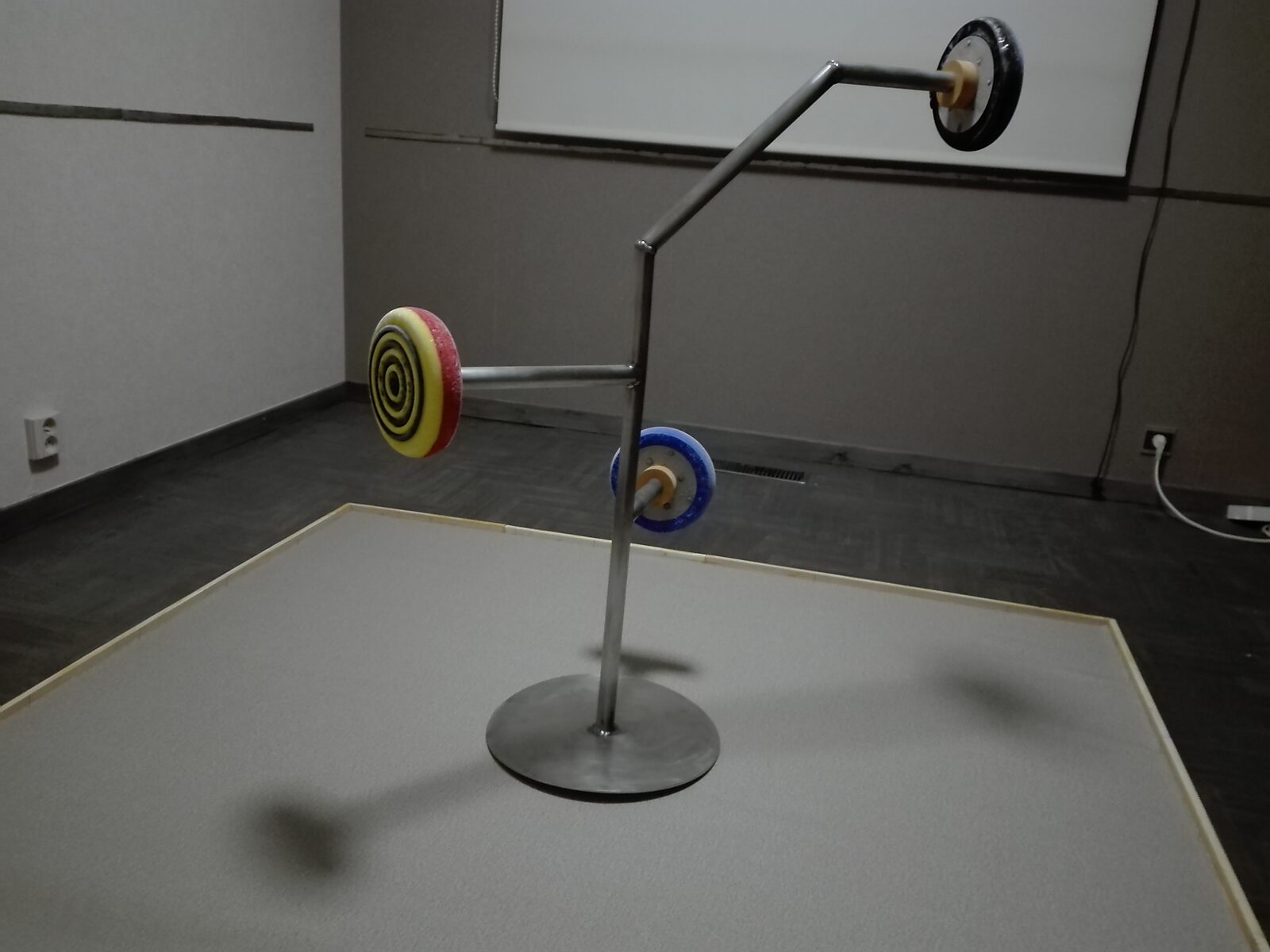 Smeltende doelen nr. 1 — statief met drie ijsdoelen boven een vierkant doek op de vloer.