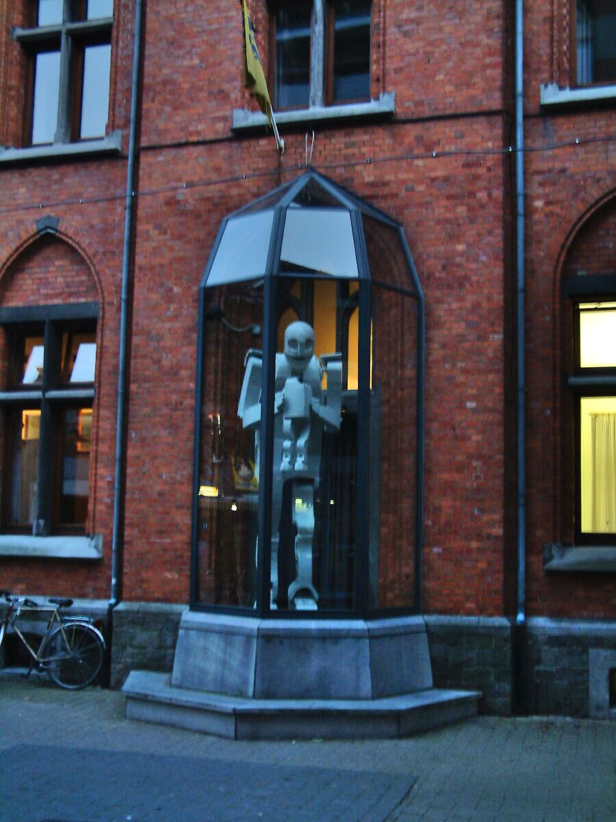 ‘Smaak’: Sculpture of a figure inside a glass display case against the brick façade of the building; exterior view of CC De Breughel, Bree, 2005