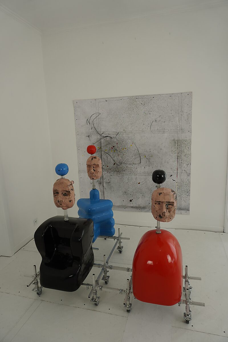 Kies en verander — atelieropstelling met drie sculpturen voor een wandtekening, opgebouwd uit polyester vormen en metalen verbindingen.