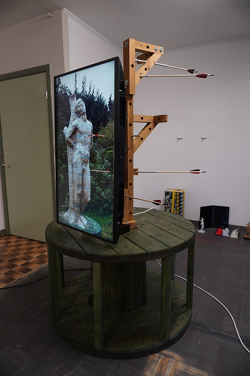 St. Sebastian with Birds No. 3 — exhibition setup with a TV screen showing live footage of the sculpture in the artist’s garden.