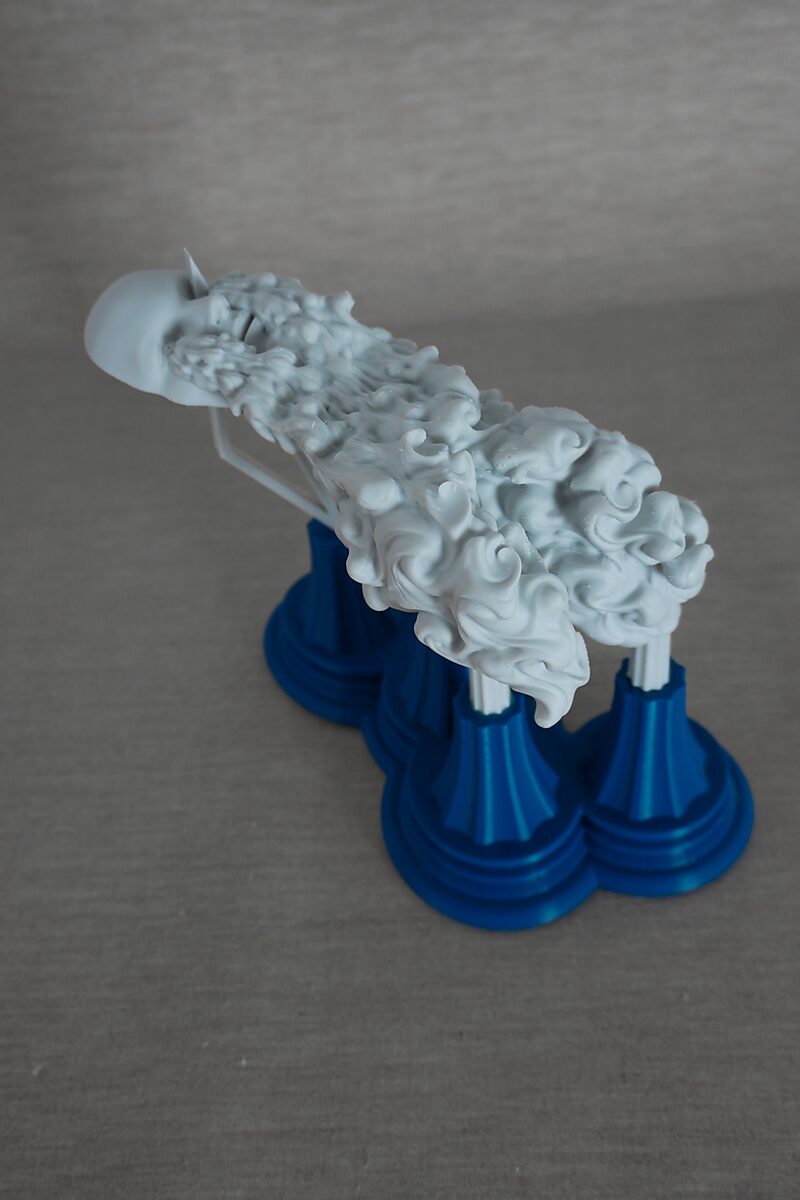 De zuilen van Ovidius — Byblis — schuin bovenaanzicht van een langgerekte sculptuur met golvende oppervlaktestructuur gedragen door zuilen op blauwe sokkels.
