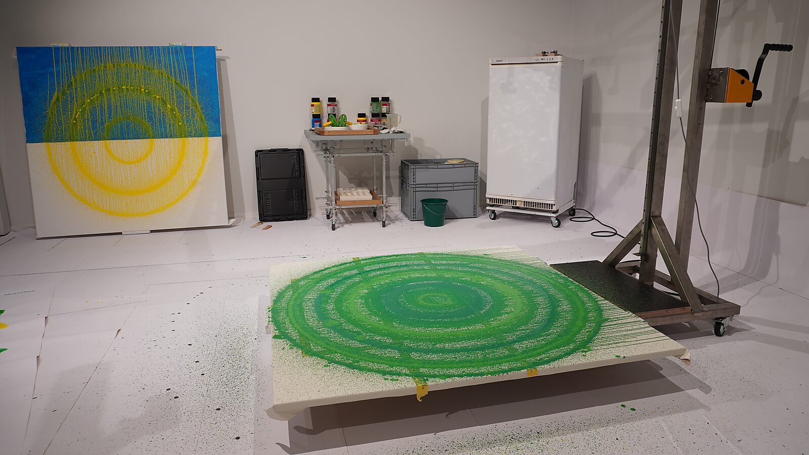 Smeltende doelen nr. 4 — werkproces op de tentoonstelling met groene concentrische cirkels op een liggend doek, Transformatiestudio nr. 1: warm of koud, CC De Adelberg, Lommel.