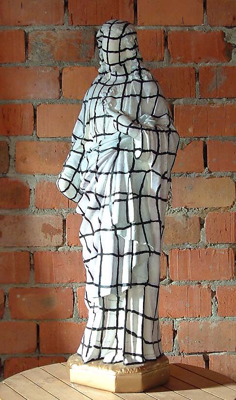 Raster Christus, Raster Christ — sculptuur waarin een heiligenbeeld de huid van een digitaal model draagt; het geschilderde raster suggereert dat religie zelf een nieuwe drager krijgt, balancerend tussen fysieke aanwezigheid en een mogelijke toekomstige, 