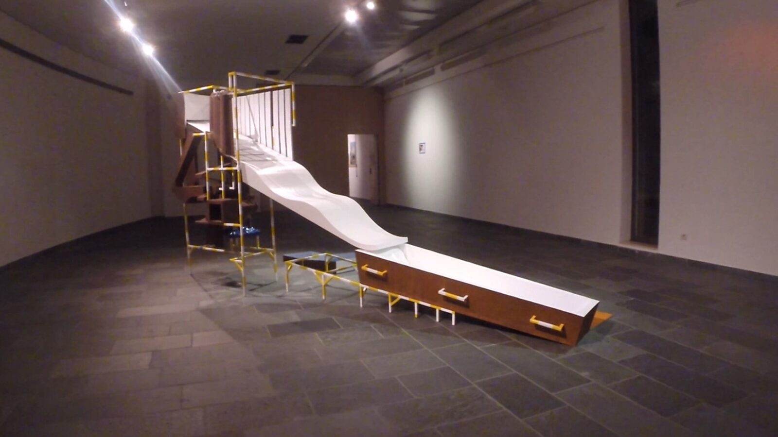 Construction with Blue — video still showing the endpoint of the installation, where movement culminates in a coffin-shaped volume, read as a transition from life to death within the architectural life line.