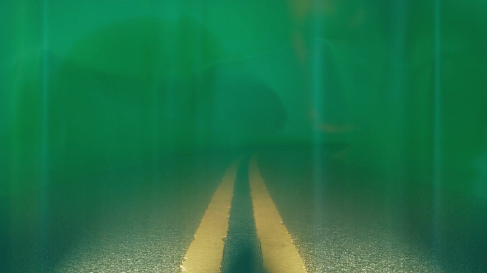 Virtual Transformation — Reversing Landscape: video still from a 3D animation; the landscape dissolves into a green veil that floods the view, leaving the road only faintly visible as a vanishing trace.