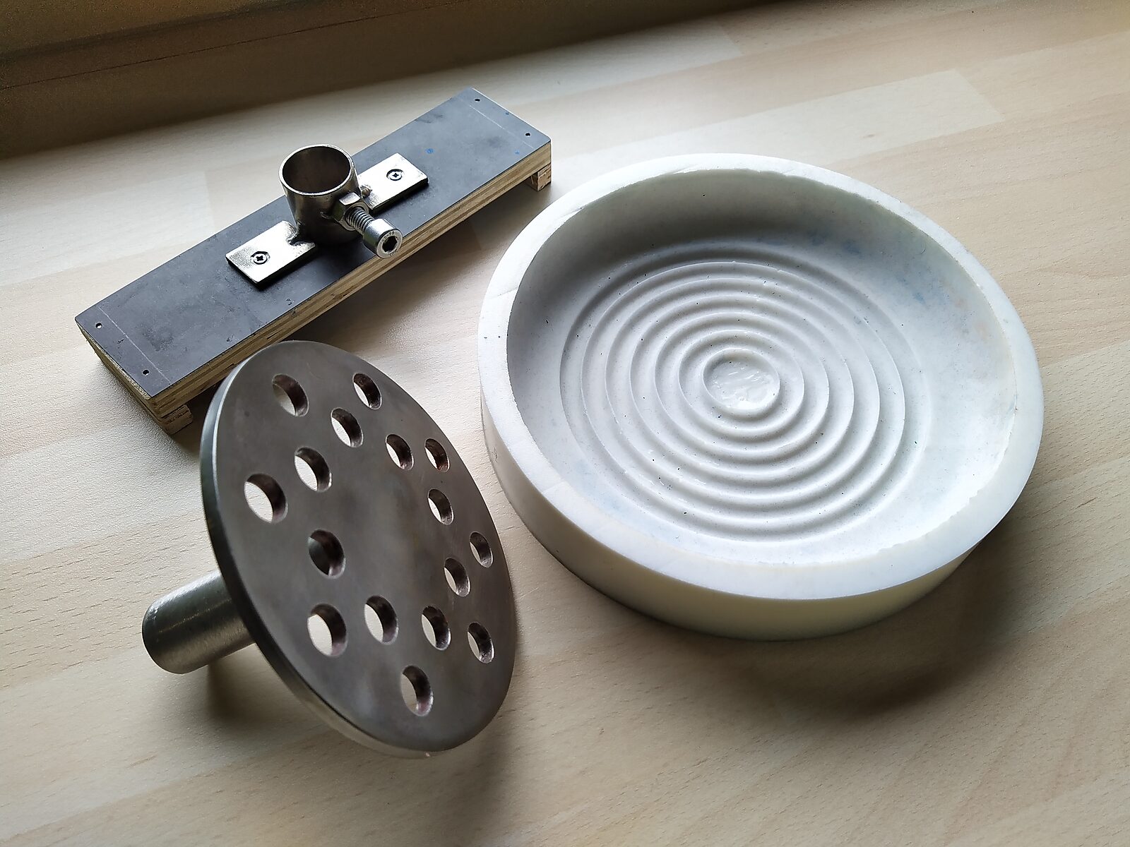Smeltende doelen — onderdelen van de mal voor de ijsdoelen: een metalen houder, een geperforeerde schijf en een ronde siliconen mal.