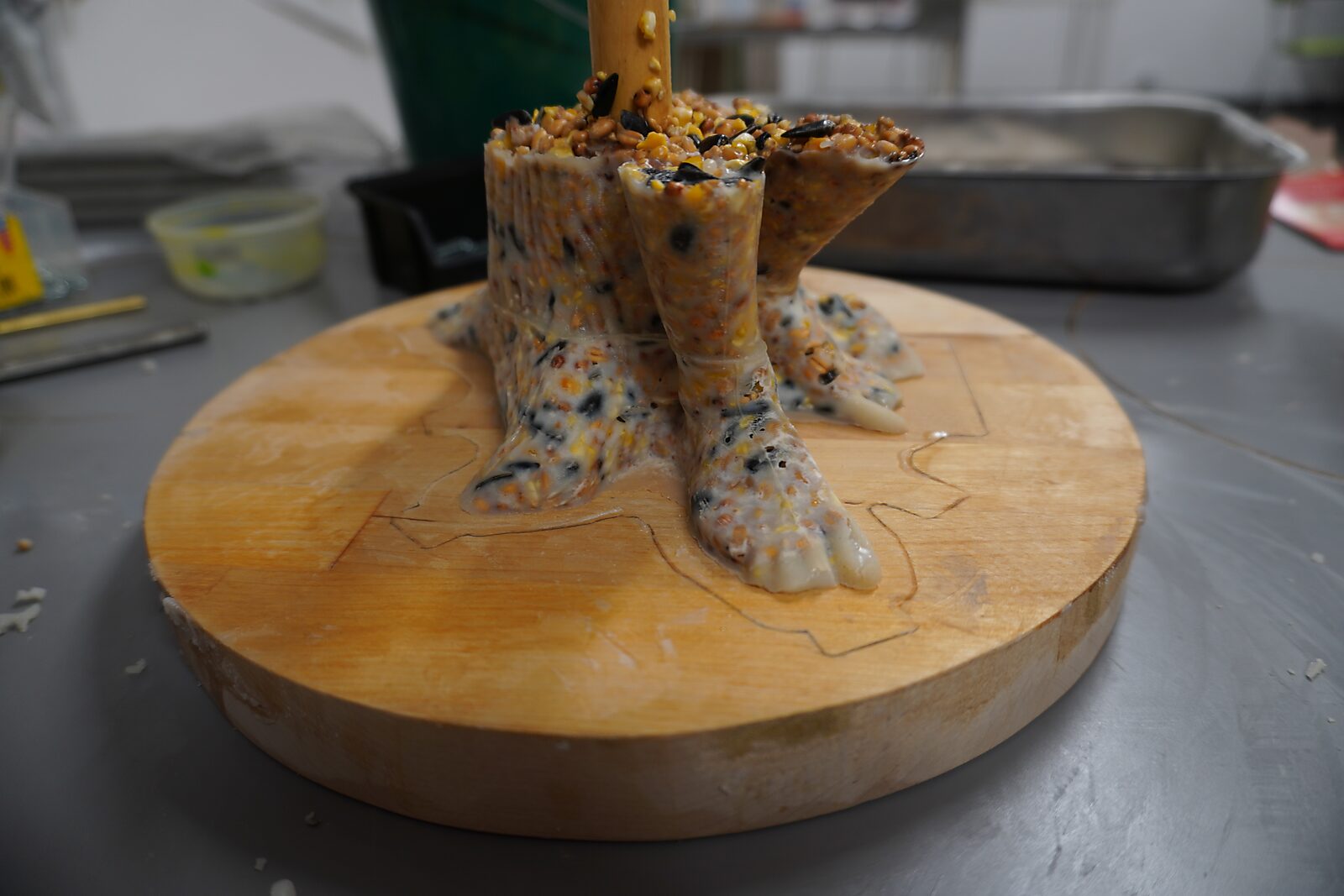 St. Sebastian with Birds No. 2 — process photo with a detail of the cast feet of the figure in fat and birdseed on a wooden base.