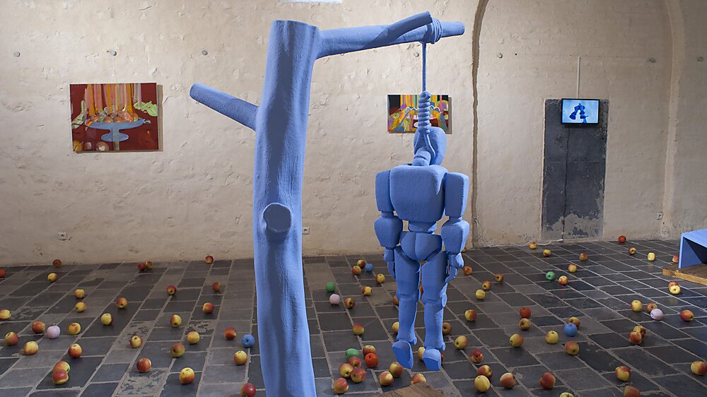 Strange Fruit — robotfiguur hangend aan een constructie die verwijst naar een boom, waarbij het mechanische lichaam wordt gepositioneerd tussen object, symbool en stilleven.