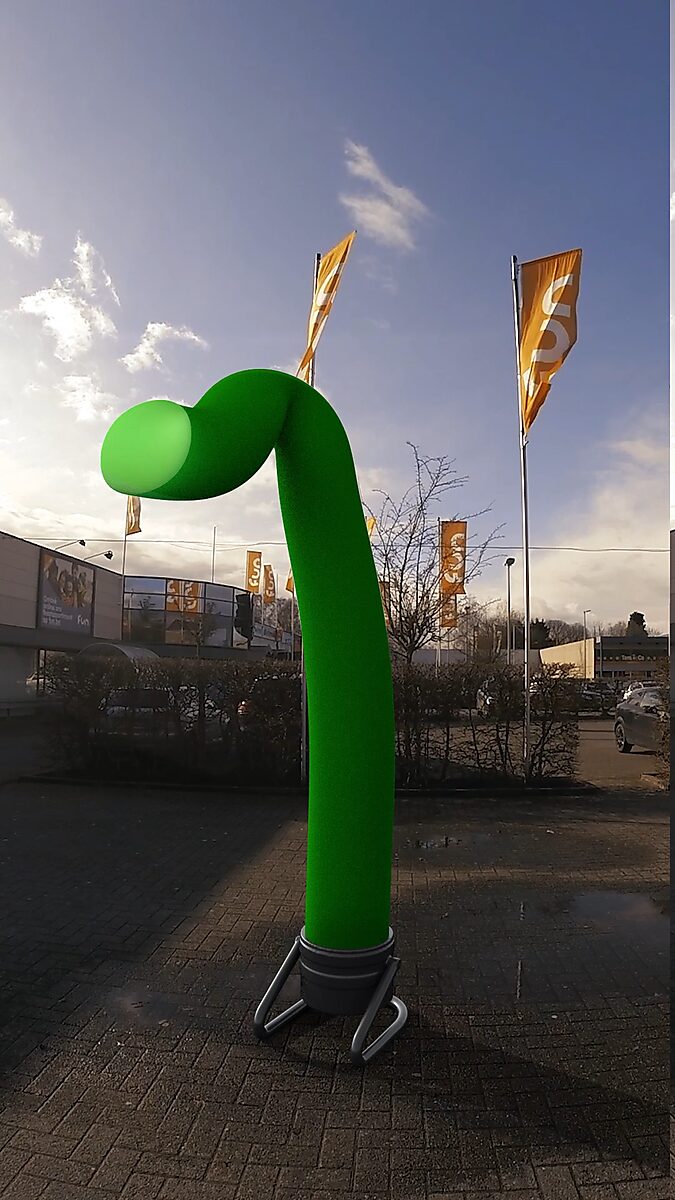 Verzet van een skytube — videostill uit een 3D-animatie van een groene skytube die langzaam buigt en vervormt, terwijl op de achtergrond vlaggen hevig in de wind wapperen.