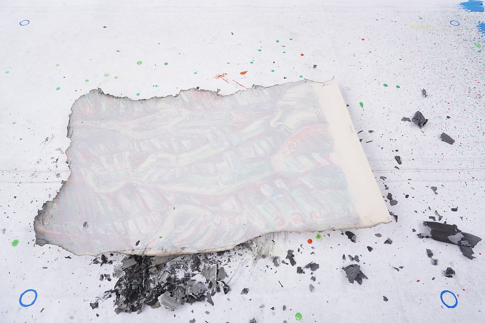 Naming–Value Butterflies — process drawing: Hanging Man (1995) — the partially burned sheet lies on the table with charred edges and grey ash around it.