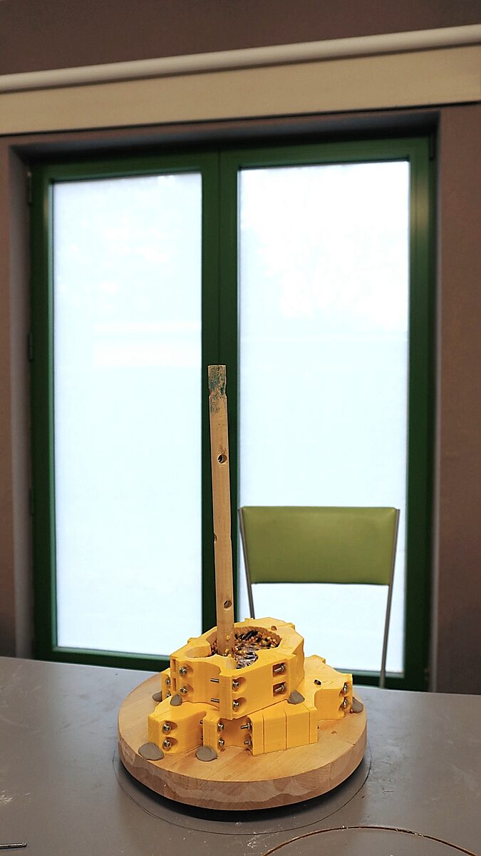 St. Sebastian with Birds No. 2 — video still of the process in which the yellow modular mould is assembled around the sculpture on a round wooden base.