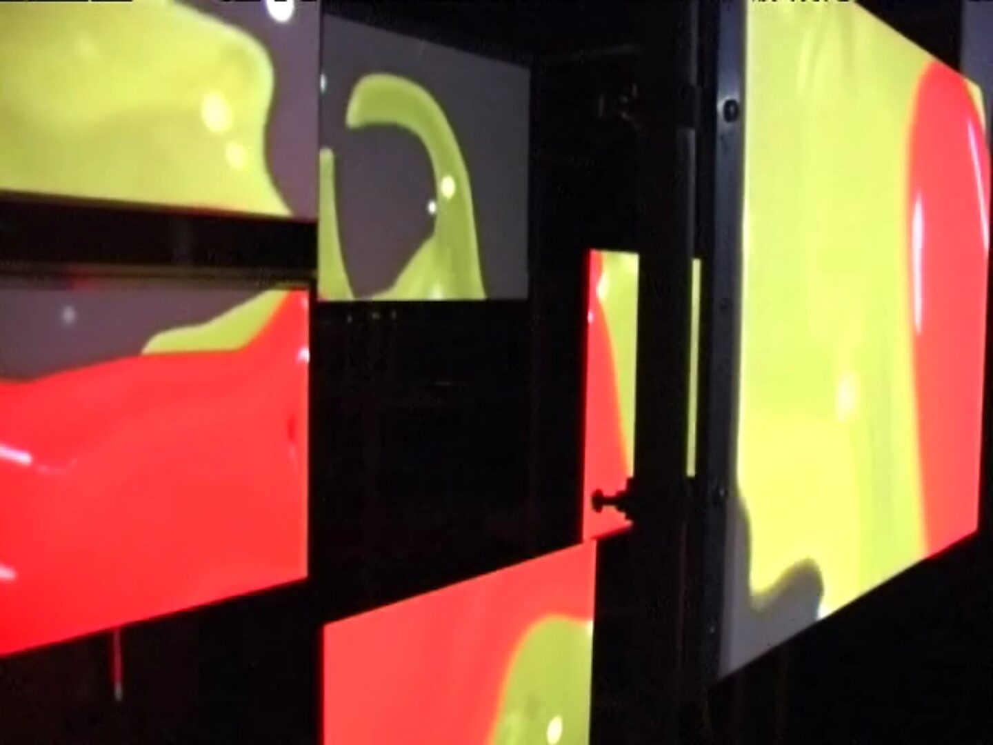 Choose and Change, Liquid Forms Through Space — detail photo: close-up of projection panels with overlapping yellow and red fluid shapes.