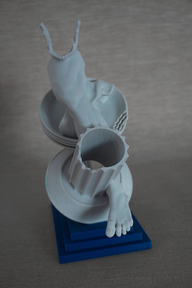The Columns of Ovidius — Erysichthon — top view of a human figure surrounded by circular structures and a broken column fragment on a blue pedestal.