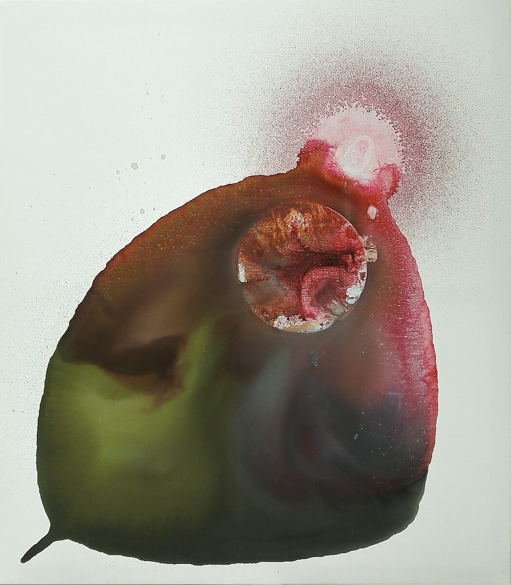 Abstract form in red, brown, and green spreading across a white surface, with a central circular opening or inserted round element and a mist of spray paint above.