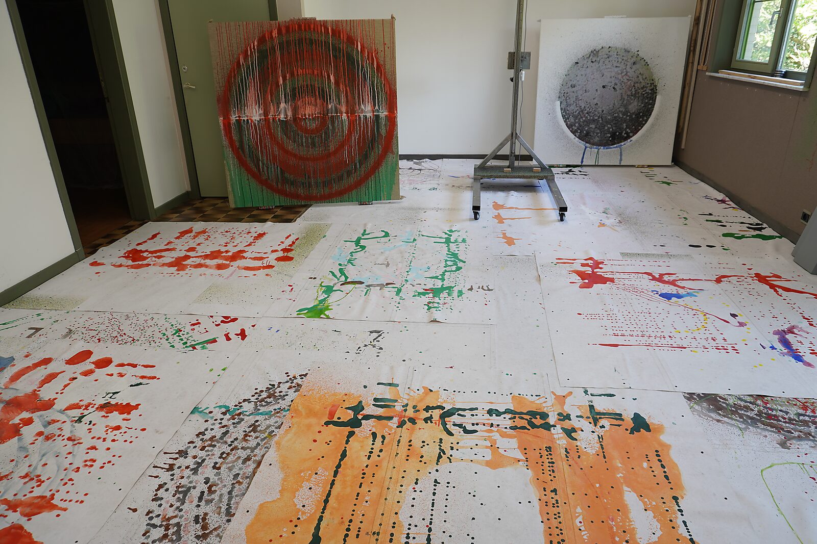Melting Targets No. 4 — studio view with several canvases on the floor showing paint traces and imprints from the working process.