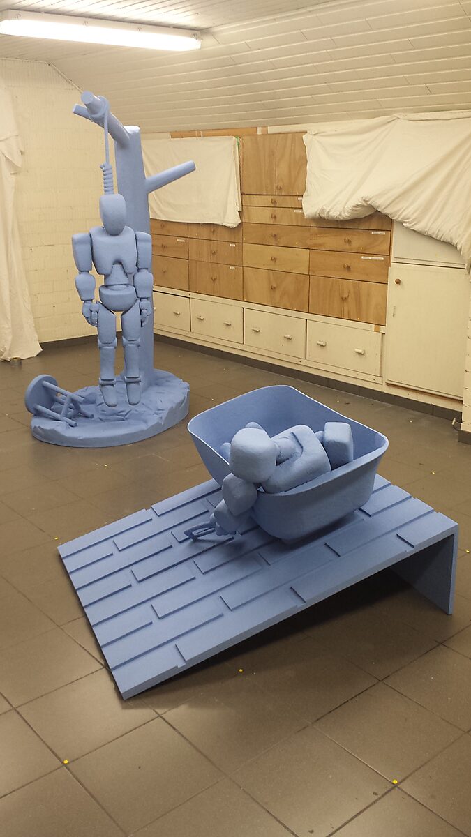 Robot in Denial — sculpture of a robot lying inside a bathtub positioned on an inclined platform, causing the body to appear suspended between rest and surrender.