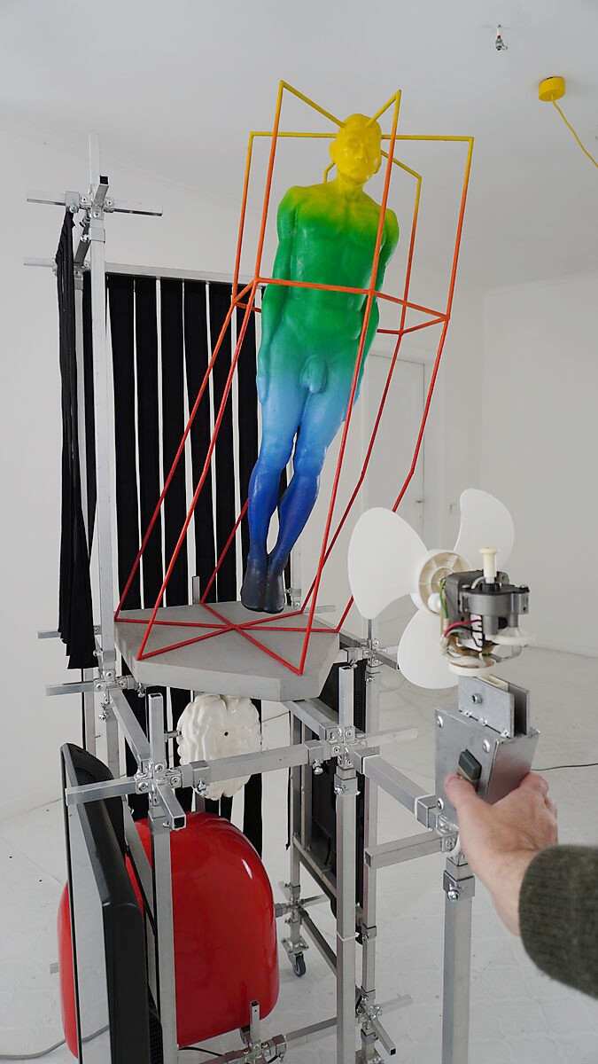 Thermal Promise — detail showing a hand activating the fan, directly linking human action to the creation of wind and movement within the installation.