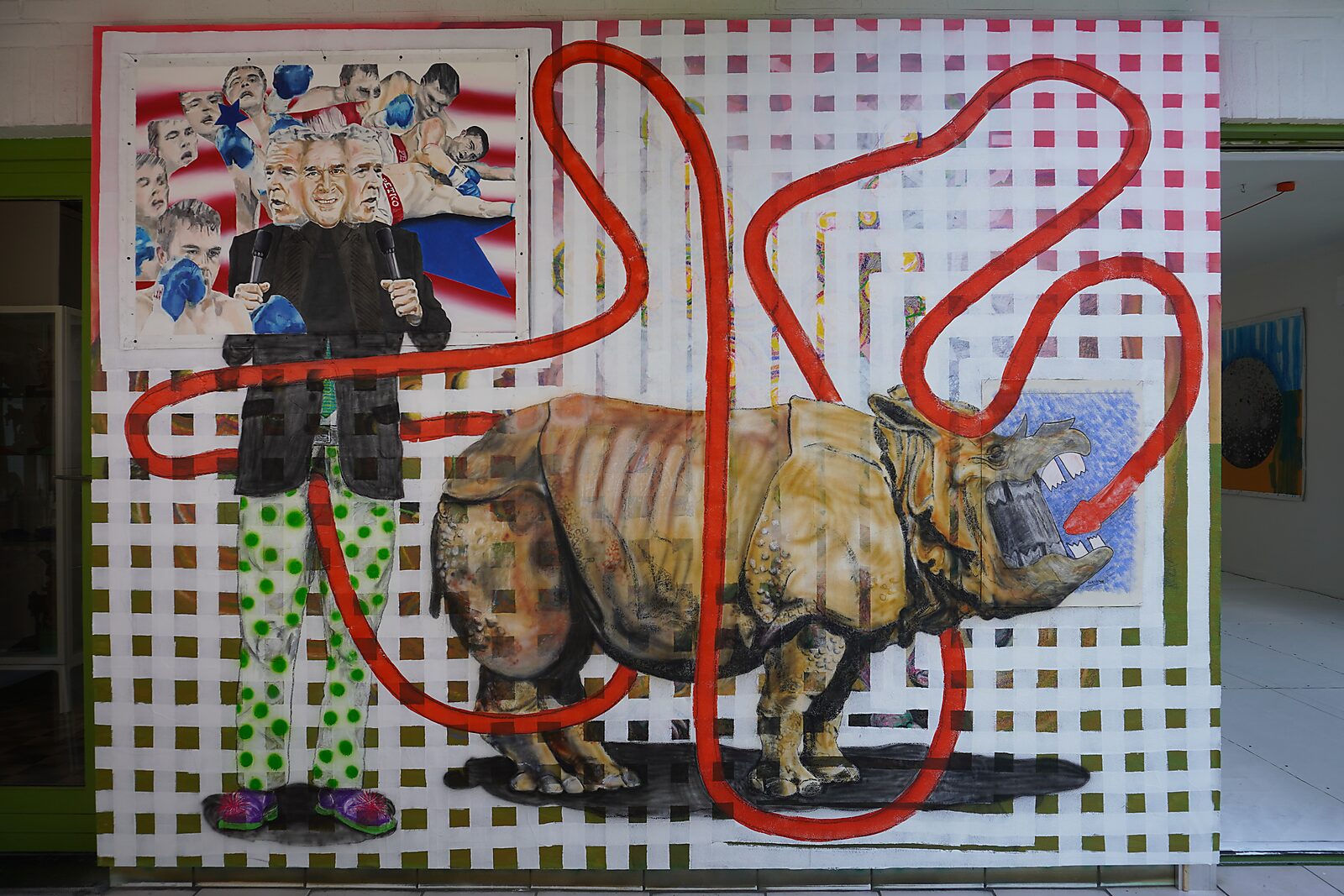 Handtekening van een neushoorn — Signature of a Rhinoceros — procesfoto: werk in opbouw waarbij een figuur en een neushoorn verschijnen op een groot rasterachtig doek met een rode lijn die door de compositie loopt.
