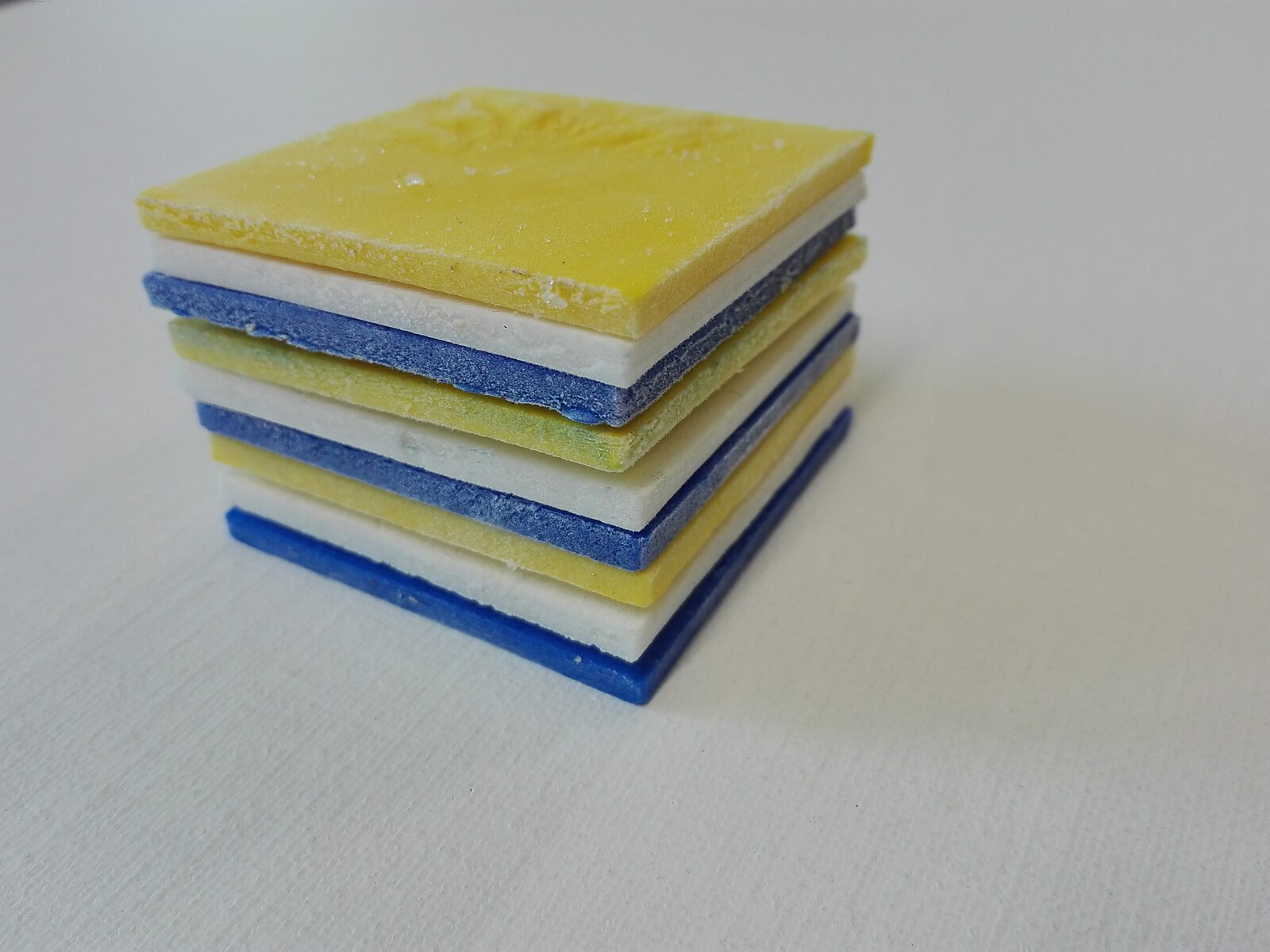Smeltende composities — stapel kleine vierkante plaatjes van gekleurd ijs, gebruikt als tijdelijk schildermateriaal dat tijdens het smelten pigment op doek achterlaat.