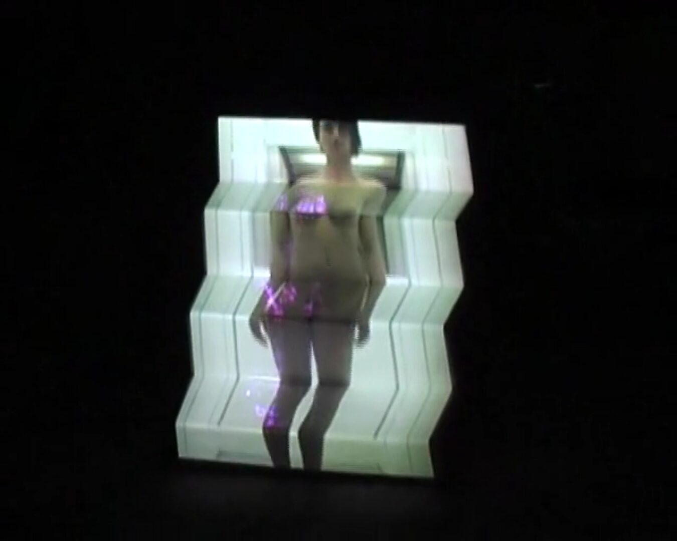 Nu descendant par un ascenseur — videostill van een geprojecteerde vrouwelijke figuur in een verlichte trapsgewijze vorm, waarbij het lichaam optisch vervormt door de structuur van het object.