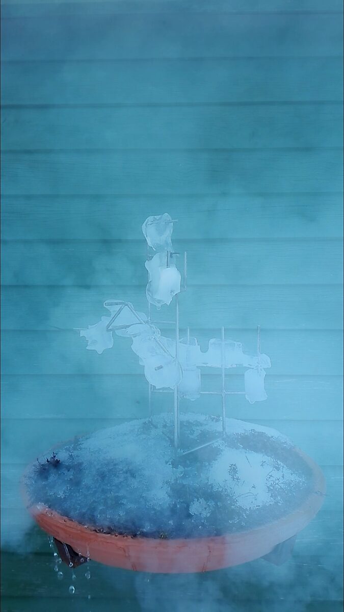 Entropic Sculpture No. 1 — videostill of the sculpture in winter where ice forms are partly melted and mist or vapor surrounds the metal armature.