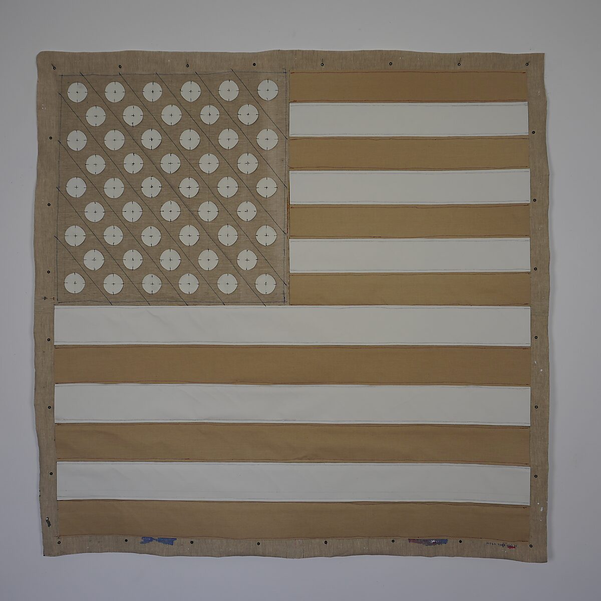 Linnen doek uitgewerkt als een interpretatie van de Amerikaanse vlag met horizontale stroken en een veld van cirkels linksboven; aan de kleurzijde is de tekst “MAGA” zichtbaar.