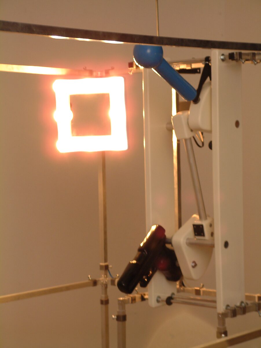 Choose and Change, Installation for a Selfish Rapper — detail photo: close-up of an illuminated square panel and a mechanical arm within the installation.
